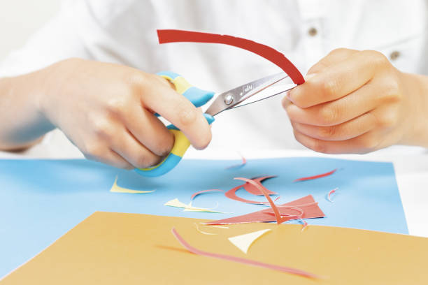 istock Child hands cutting colored paper with scissors at the table 954114720