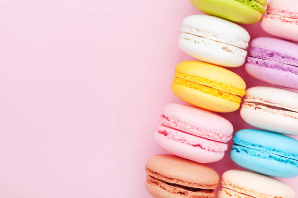 istock French dessert macaron or macaroon on pink pastel background top view. Flat lay. 954119550