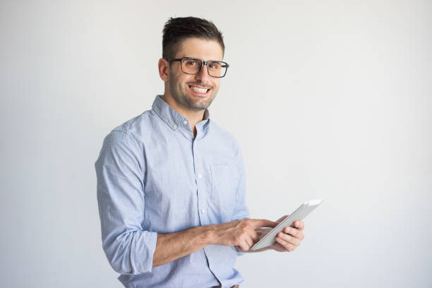 istock Smiling young businessman wearing glasses using digital tablet 954120658