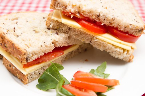 A plate of cheese and tomato vegan sandwiches