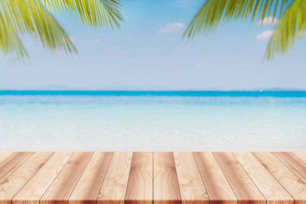 istock Empty wood table top and blurred Palm tree summer beach with blue sea and sky background. - can used for display or montage your products. 954124824
