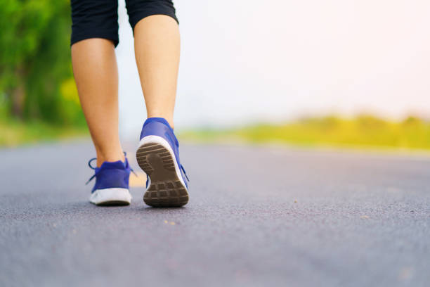 istock Woman feet running on road 954125564