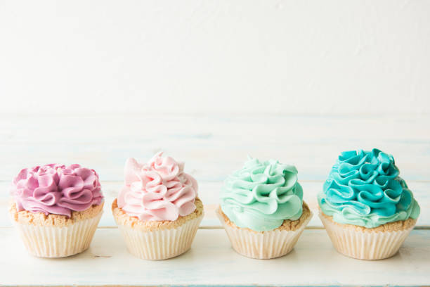 istock Four colorful cupcakes on a light background. Copy space 954125986