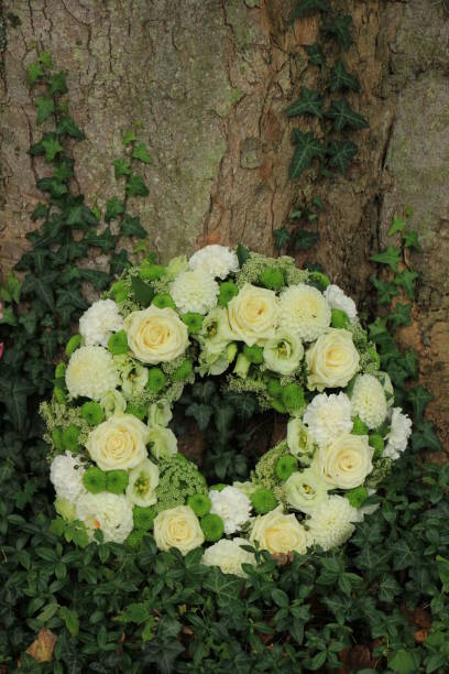 istock white sympathy wreath near a tree 954128988