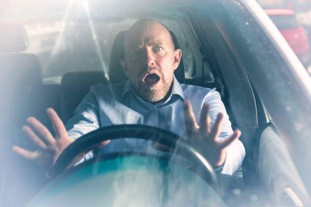 istock Man looks shocked while driving a car 954140512