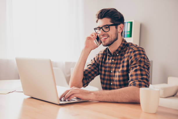 istock Young businessman talking on phone while working with laptop 954141136