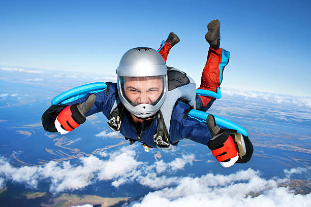 Skydiver Skydiver falls through the air. All right! Thumbs up! Parachuting is fun! sports helmet photos stock pictures, royalty-free photos & images