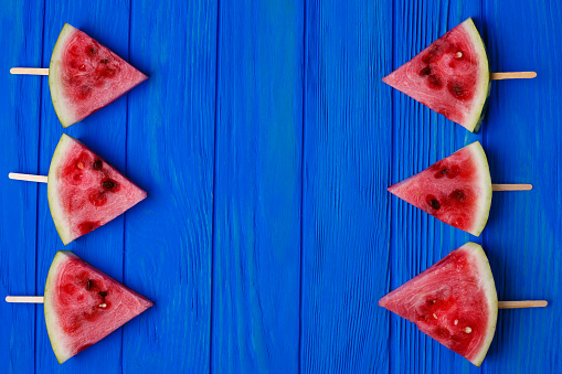 Watermelon slices on blue wooden background, free space for advertisement or text. Fruits, freshness, summer concept