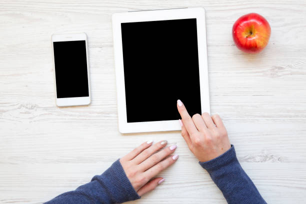 istock Feminine workspace with smartphone, tablet and apple. Top view. From above. 954148918