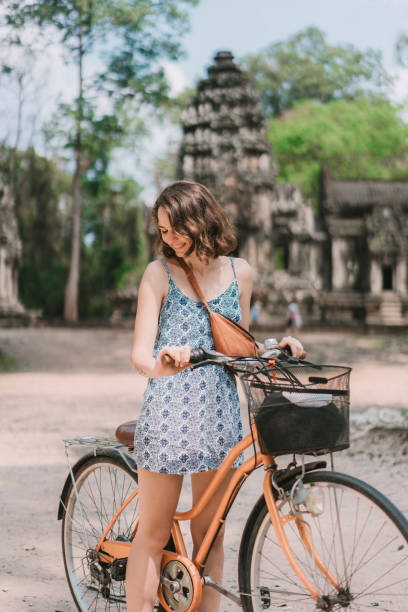 istock Young Caucasian woman riding  bicycle  in Angkor Wat 954149108