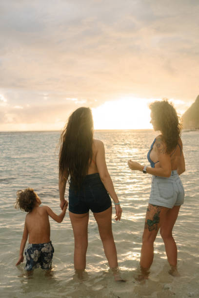 istock Two women  playing with little boy  on the beach 954149446
