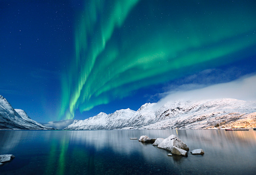 Green aurora borealis at jokulsarlon reflecting the midnight sky, Tromso, Norway.