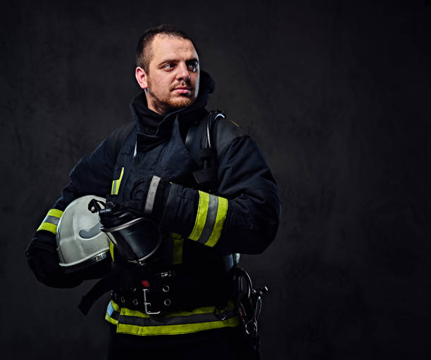 istock Firefighter dressed in uniform holds safety helmet. 954157118