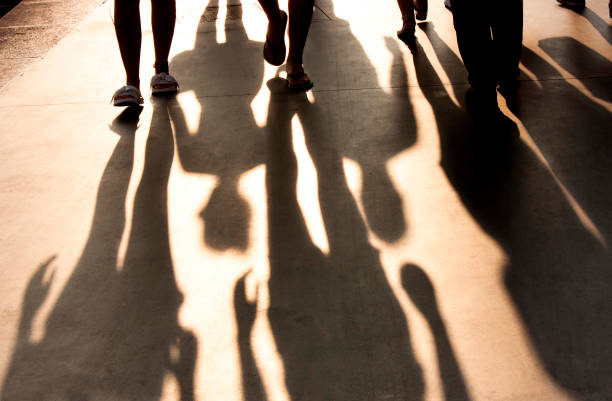 istock Blurry shadows of people walking on summer promenade 954157474