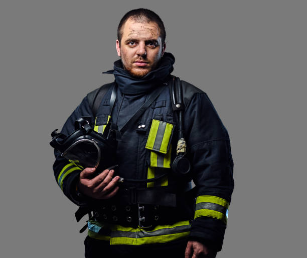 retrato de estudio de un hombre vestido con un uniforme de bombero. - fire department heroes portrait occupation fotografías e imágenes de stock