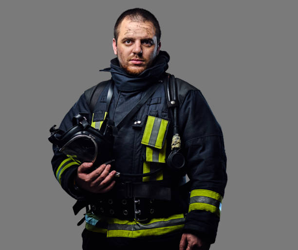 Studio portrait of a male dressed in a firefighter uniform. stock photo