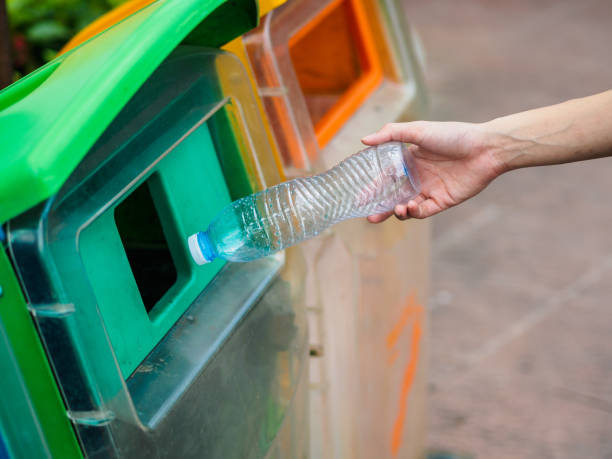istock Closeup portrait woman hand throwing empty plastic water bottle in recycling bin. 954161482