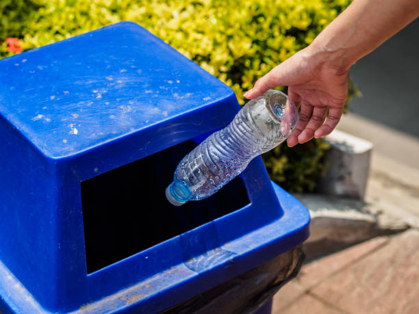 istock Closeup portrait woman hand throwing empty plastic water bottle in recycling bin. 954161528