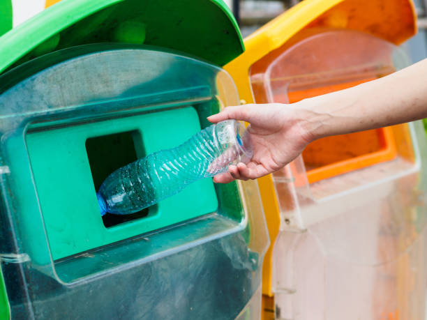istock Closeup portrait woman hand throwing empty plastic water bottle in recycling bin. 954161536