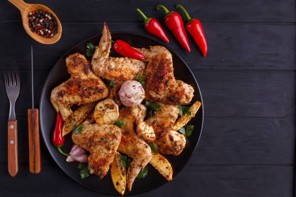 istock Very hot grilled chicken wings on black plate decorated with gar 954162206