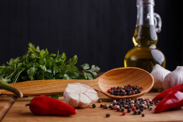 Herbs and spices, olive oil, garlic on wooden table. Kitchen background, seasoning, ingredients for food cooking concept