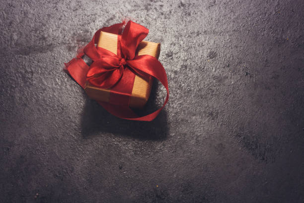 istock small gift box with thin red ribbon on  wood table 954166916