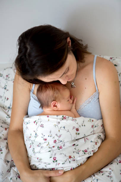 istock Young mother lying in bed with her newborn baby boy 954168366