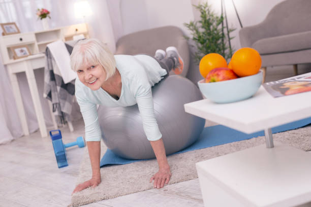 istock Charming senior woman doing plank while lying on yoga ball 954169038