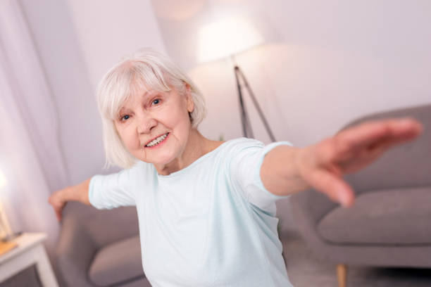 istock Happy elderly woman posing with arms spread and smiling 954172108