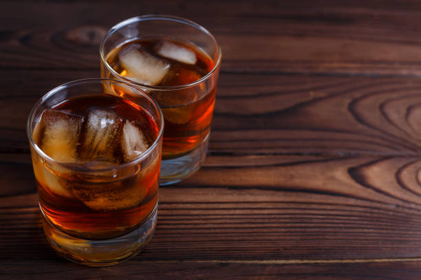 istock Whiskey with ice cubes on wooden table, copy space.  Alcohol dri 954173530