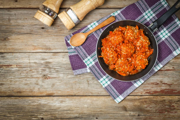 istock meatballs, tomato sauce, frying pan, coocking, vegetables, copy space, wooden background, rustic style, napkin, eating outdoors 954174166