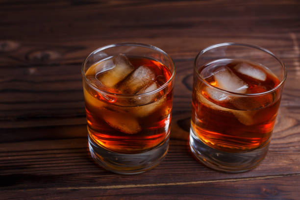 istock Whiskey with ice cubes on wooden table, copy space.  Alcohol dri 954176914