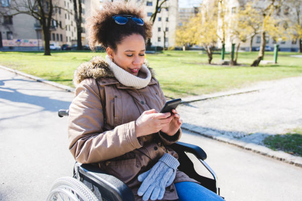 istock Woman with disability sitting in a wheelchair and using smart phone 954196942
