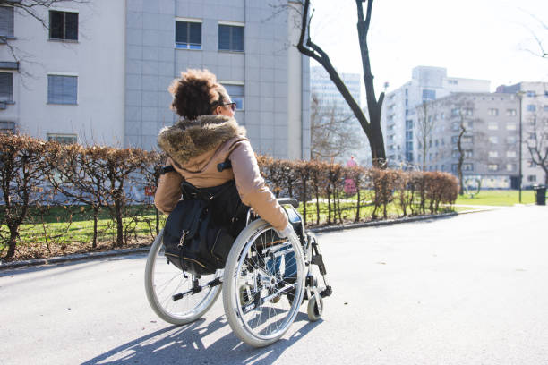 istock Disabled woman in a wheelchair in a park 954196976