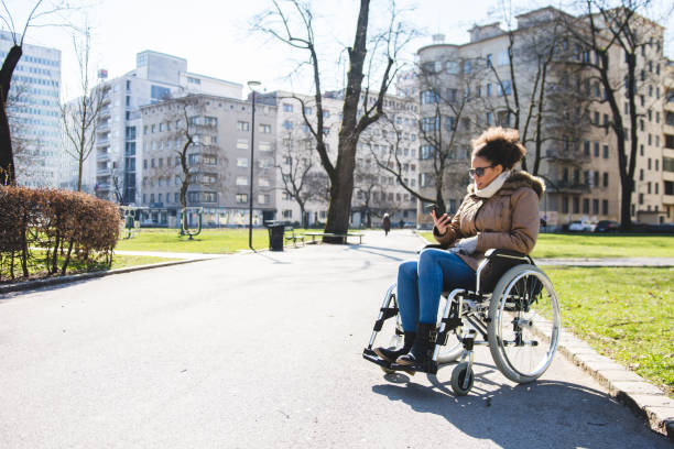 istock Disabled woman sitting in a wheelchair and using smart phone 954197044
