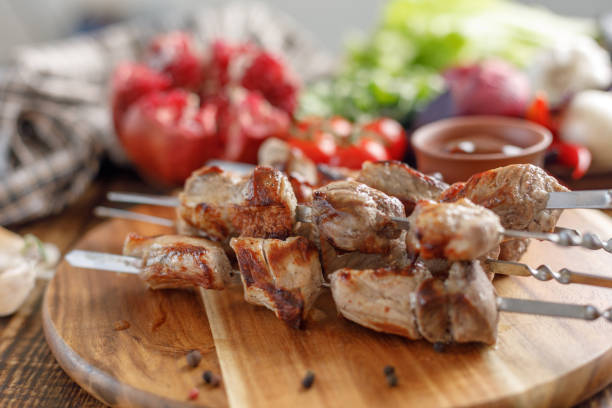 istock Shish kebab from pork. Appetizing meat cooked on an open fire and fresh vegetables. Rustic. 954202904