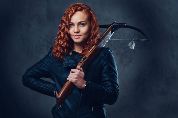 rothaarige frau hält armbrust. - archery bow arrow women stock-fotos und bilder