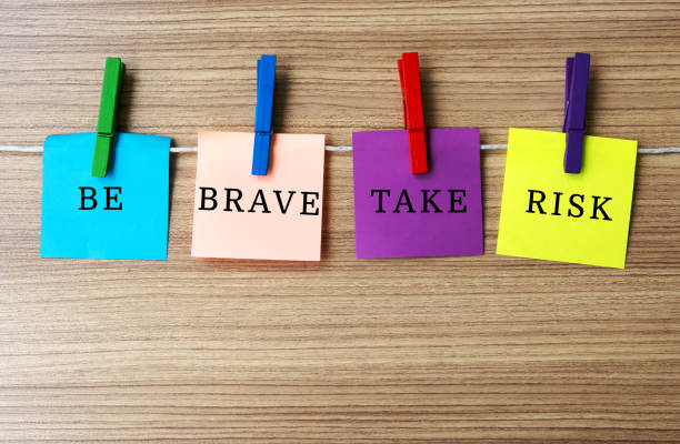 istock Inspirational quote - Be brave take risk on notes hanging by clothespins 954216490
