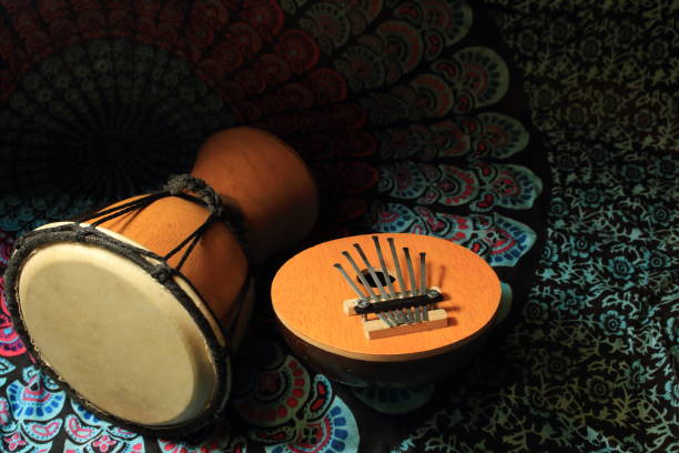 istock Two african musical instruments (calimba, drum) lie on a colorful scarf. 954222050