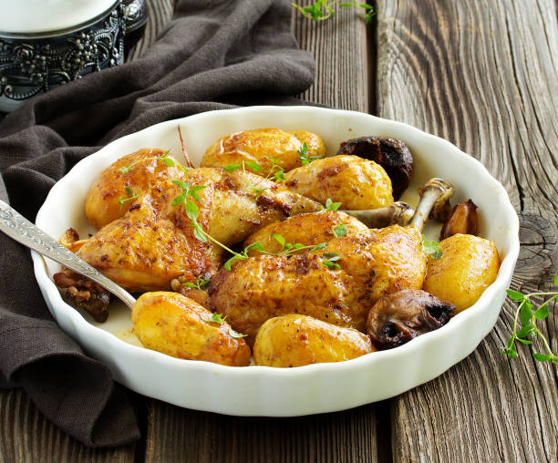 istock Baked chicken thigh with potatoes and vegetables. 954225388