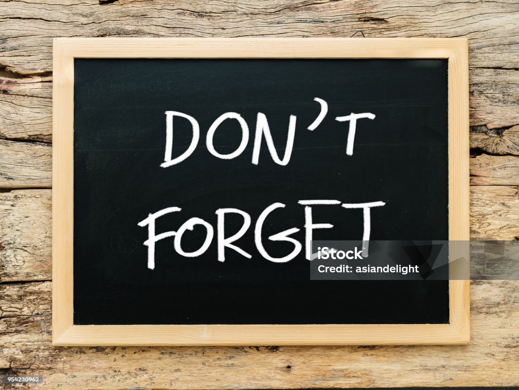 text "don't forget" on black chalkboard with wooden background. meeting remind reminder note concept Reminder Stock Photo