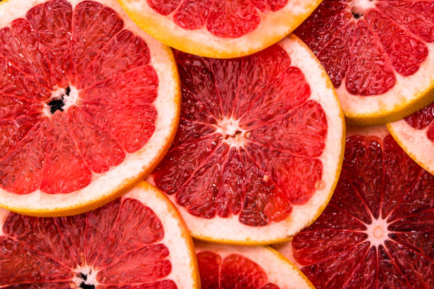 istock Sliced grapefruits, background, natural texture of citrus, top view, close-up 954231626