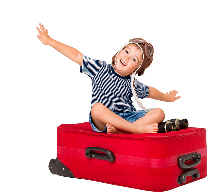 Child Flying on Travel Suitcase, Kid Pilot in Aviator Hat Sitting on Red Luggage, Baby Boy Isolated over White Background