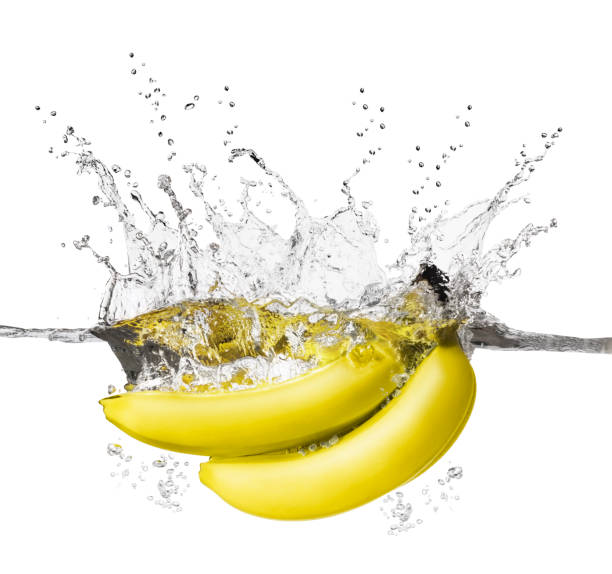 istock Ripe yellow bananas splashing into water isolated on white 954234860