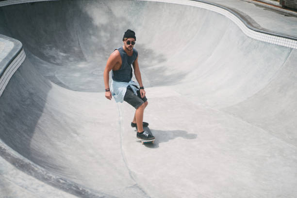 istock handsome skater skating in pool at skatepark 954241428