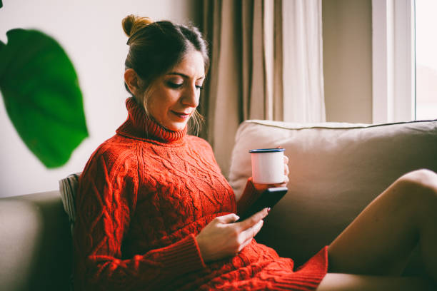 istock Beautiful young woman looking at smartphone screen, drinking coffee (toned image, selective focus) 954242424