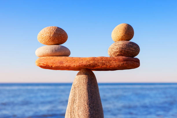 상징 비늘 클로즈업 저녁 태양, 바다에 대 한 조명. 장점과 단점 개념 - stone balance zen like nature 뉴스 사진 이미지