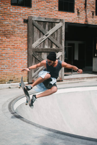 istock handsome skater jumping during skating in skatepark 954249146