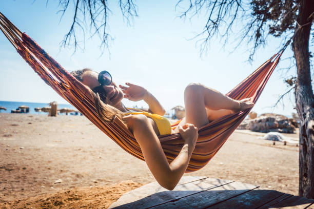 istock Woman lying in hammock close to the beach 954249198
