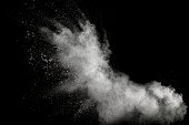Launched white powder splash on black background. Bizarre forms of of white powder explosion cloud against dark background.